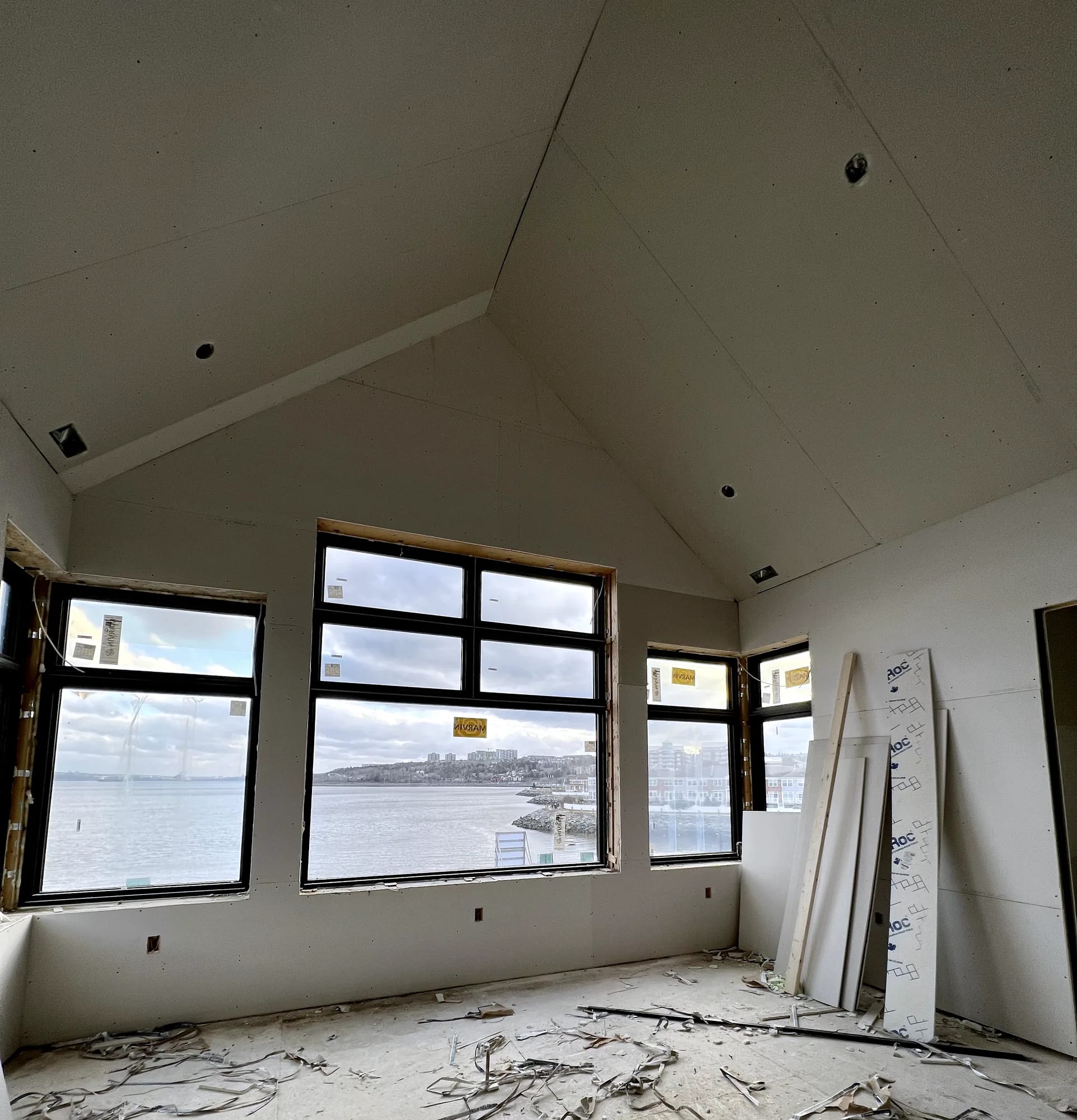 A cathedral ceiling and walls boarded in a waterfront Halifax property, looking out over the harbour