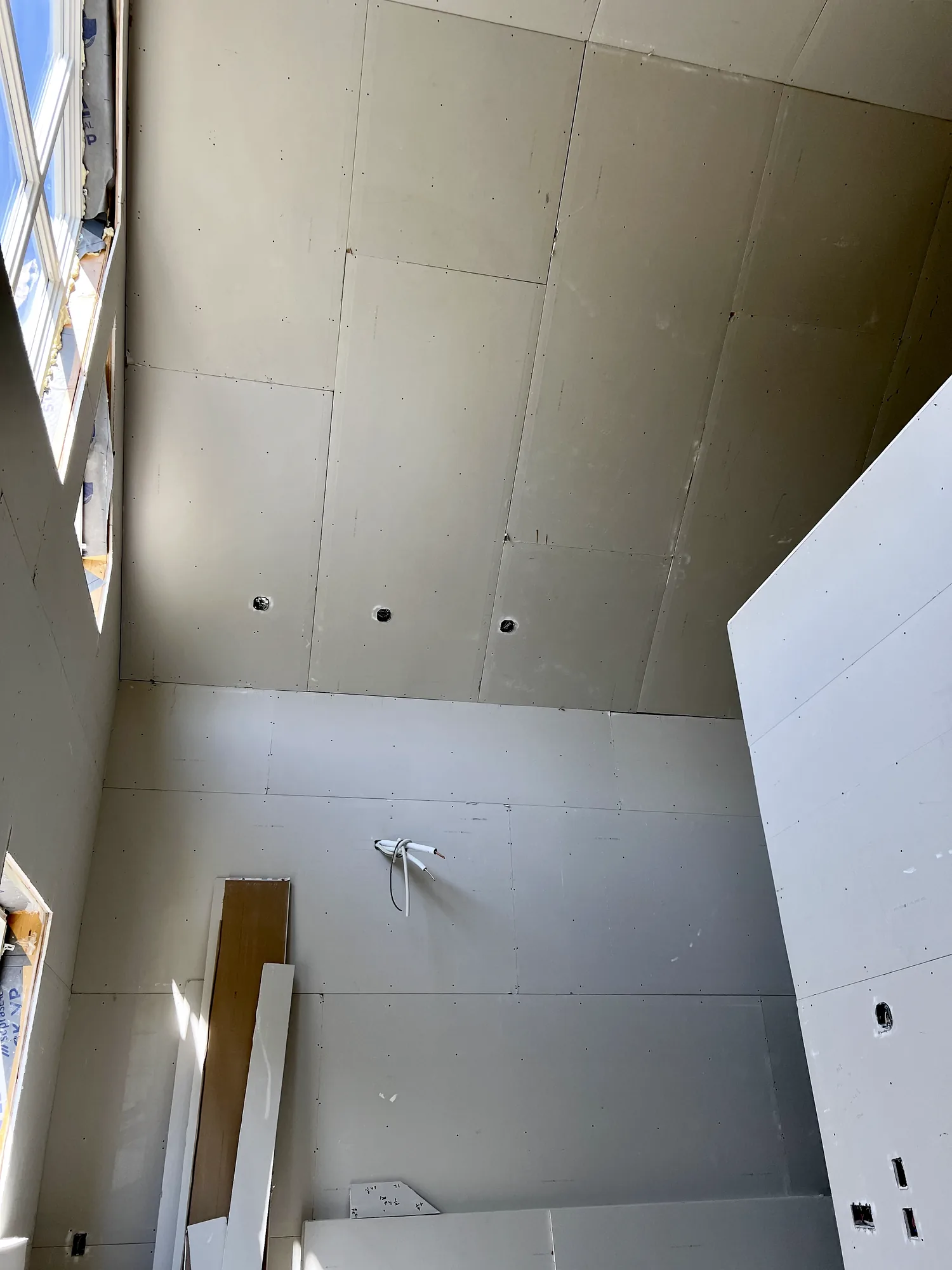Two-storey drywall installation with tall sheets and straight internal corners in a Nova Scotia build
